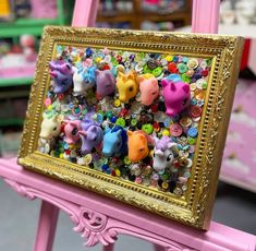 a pink chair with an ornate gold frame holding a small group of animal figurines