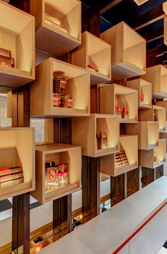 the shelves are filled with books and lit candles in each section, all lined up against one wall