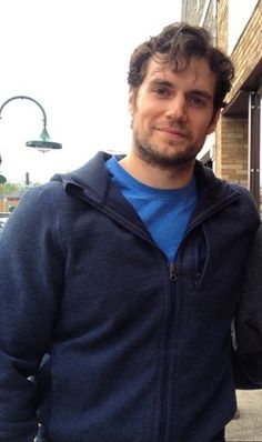 a man standing in front of a brick building