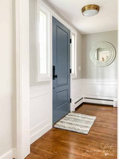 a blue door in a white room with wood floors and hard wood flooring on the side