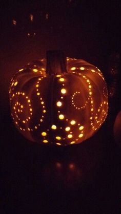 a lighted pumpkin sitting on top of a table