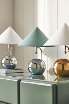 three lamps sitting on top of a dresser