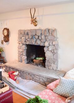 a living room with a stone fireplace and couches in front of the fire place