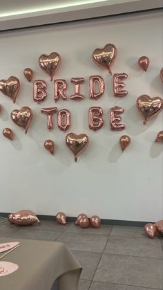 the bride to be balloons are on display in front of a white wall with rose gold foil hearts