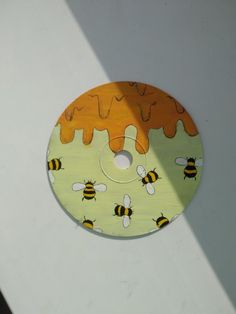 a wooden disk with bees painted on it