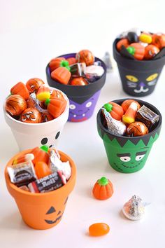 four halloween candy cups filled with candy and candies