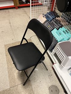 a black chair sitting on top of a tile floor next to a pile of boxes