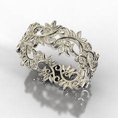 an intricately designed silver ring on a white background with shadow from the middle one