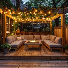 an outdoor living area with couches, lights and potted plants on the deck