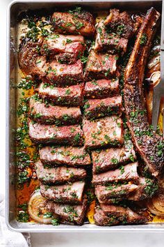 a pan filled with steak and vegetables next to a bowl of sauce on the side