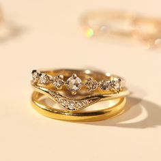 three gold wedding bands with diamonds on them