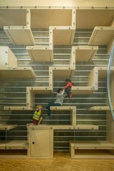 two people are sitting on some shelves in a room with metal bars and shelving