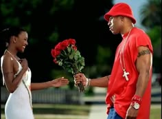 a man is handing flowers to a woman