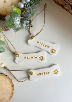 three dog bone ornaments with words written on them