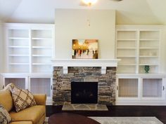 a living room filled with furniture and a fire place in front of a stone fireplace