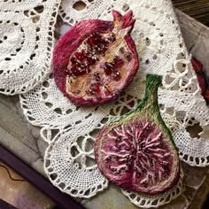 two pomegranates sitting on top of a doily