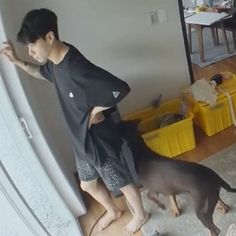 a man standing next to a dog on top of a hard wood floor