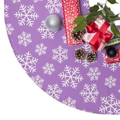 presents wrapped in red and white paper on a purple tablecloth with snowflakes