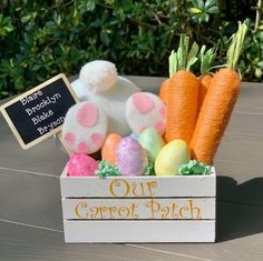 a wooden box filled with carrots and bunny eggs