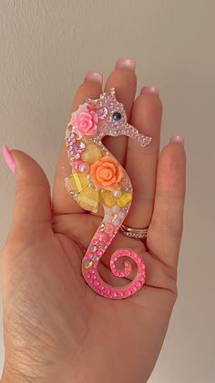 a person is holding a small toy in their hand and it looks like a seahorse