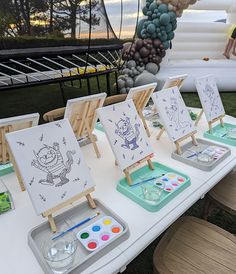 several easels with drawings on them sitting on a table