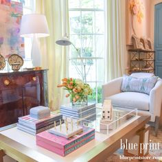 a living room filled with lots of furniture and books on top of a coffee table