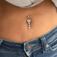 a woman's stomach with a cross tattoo on the side and pearls attached to it