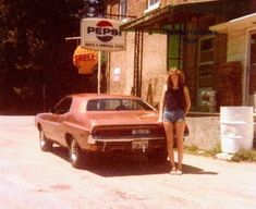 a woman standing next to a car in front of a store