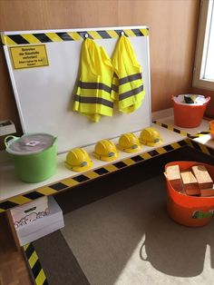 there are many buckets and yellow shirts on the table