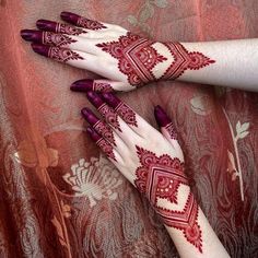 two hands with henna tattoos on them