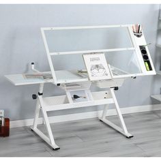 a computer desk with a glass top and white frame on the bottom, sitting in front of a gray wall