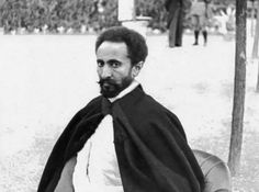 an old black and white photo of a man with a beard wearing a shawl