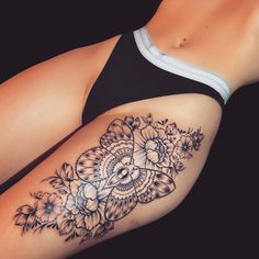 a woman's thigh with flowers and leaves on the side, in black and white