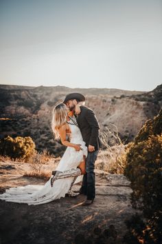 a bride and groom kissing in the desert