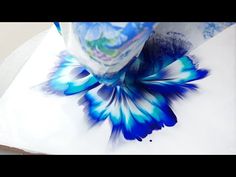 a blue and white flower sitting on top of a piece of paper