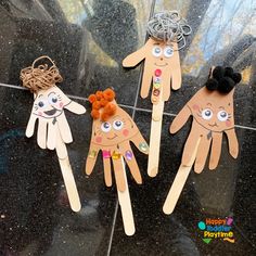 four hand puppets with faces and hair on them