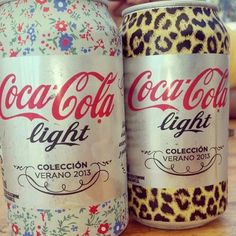 two cans of coca - cola light on a table