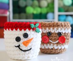 two crocheted mugs with faces made to look like snowman and elf