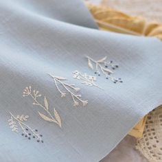 two pieces of cloth with embroidered designs on them, one is blue and the other is yellow