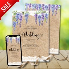 two wedding cards with purple flowers on them and a cell phone next to the card