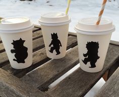 three starbucks cups sitting on top of a wooden table