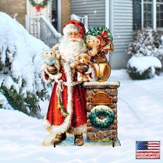 a statue of santa claus in front of a house with wreaths and teddy bears