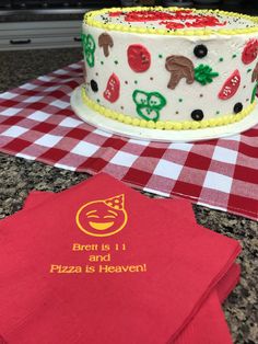 a white and red cake sitting on top of a table next to a red napkin