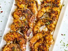 grilled shrimp with herbs on a white platter