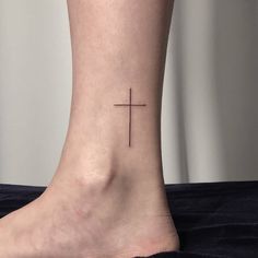 a cross tattoo on the ankle is shown in this image, it appears to have been placed