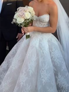 the bride is walking down the aisle with her bouquet in hand as she smiles for the camera