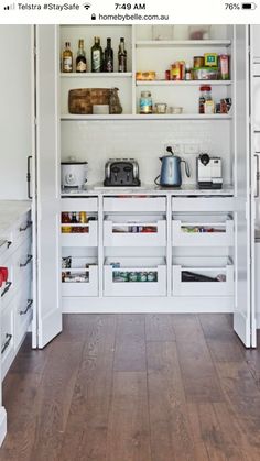 a kitchen with white cabinets and wooden floors