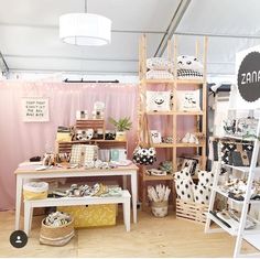 a room filled with lots of different types of furniture and decor on display in front of a pink curtain