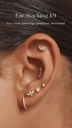 an ear with three different piercings on the top and one behind it, in front of