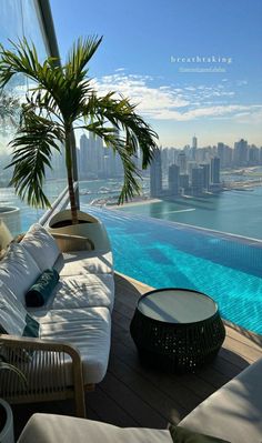 an outdoor lounge area next to a swimming pool with palm trees in the foreground